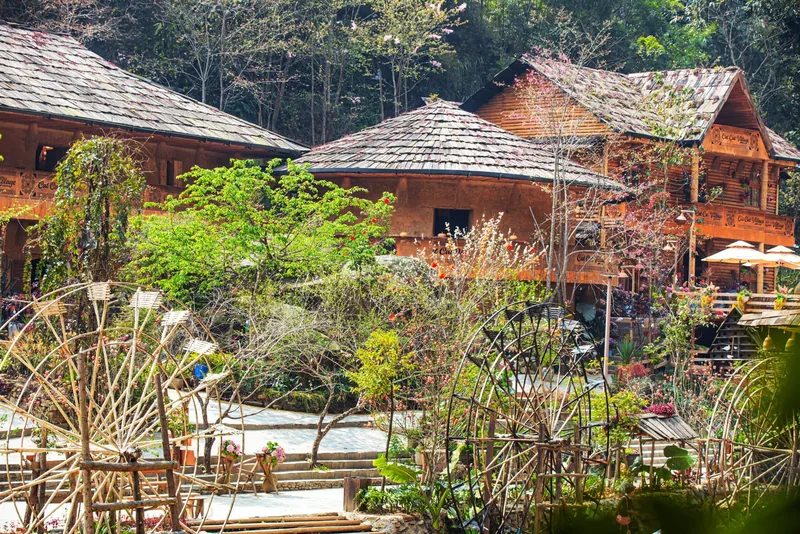 Wooden stilt houses and bamboo waterwheels surrounded by greenery in Cat Cat Village. Wooden stilt houses and bamboo waterwheels surrounded by greenery in Cat Cat Village.