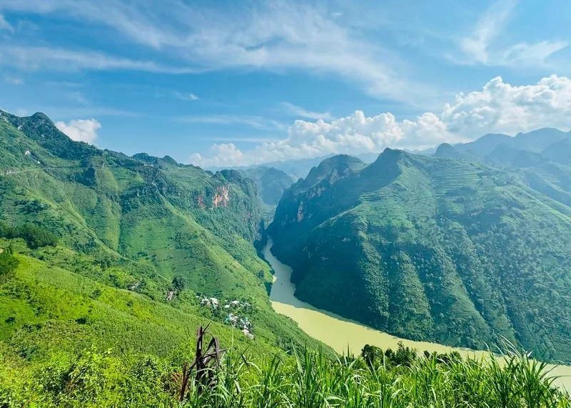 A river winds through the steep green karst mountains of the Nho Que canyon in Ha Giang. A river winds through the steep green karst mountains of the Nho Que canyon in Ha Giang.
