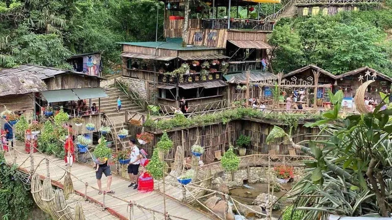 Wooden houses and hanging flower pots line a footbridge over a stream at Cat Cat Village near Sapa. Wooden houses and hanging flower pots line a footbridge over a stream at Cat Cat Village near Sapa.
