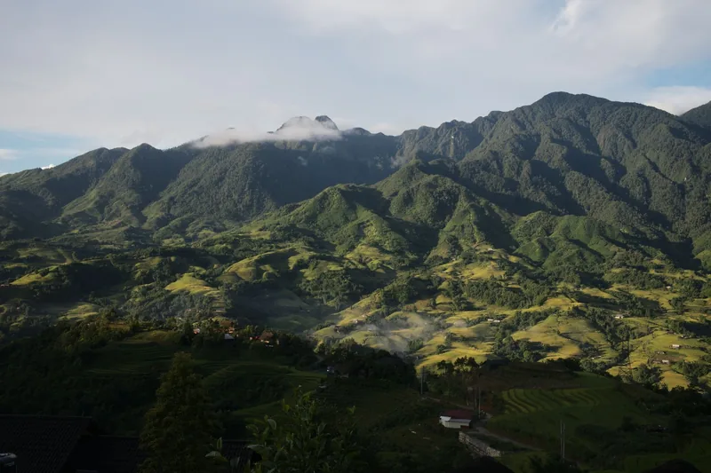 Terraced fields and forested peaks rise beneath morning mist in the mountains around Sapa, Vietnam. Terraced fields and forested peaks rise beneath morning mist in the mountains around Sapa, Vietnam.
