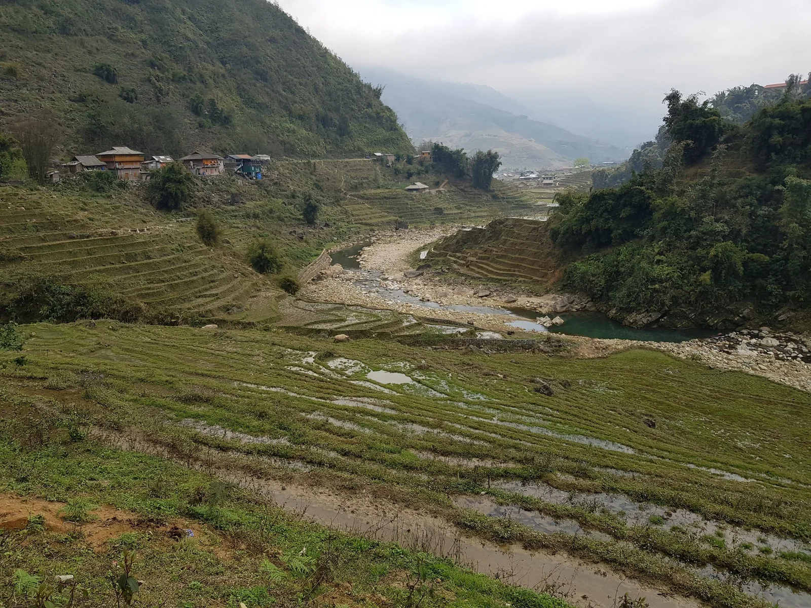 Terraced rice fields and a rocky stream wind through a misty valley near Ta Van village in Sapa, Vietnam. Terraced rice fields and a rocky stream wind through a misty valley near Ta Van village in Sapa, Vietnam.