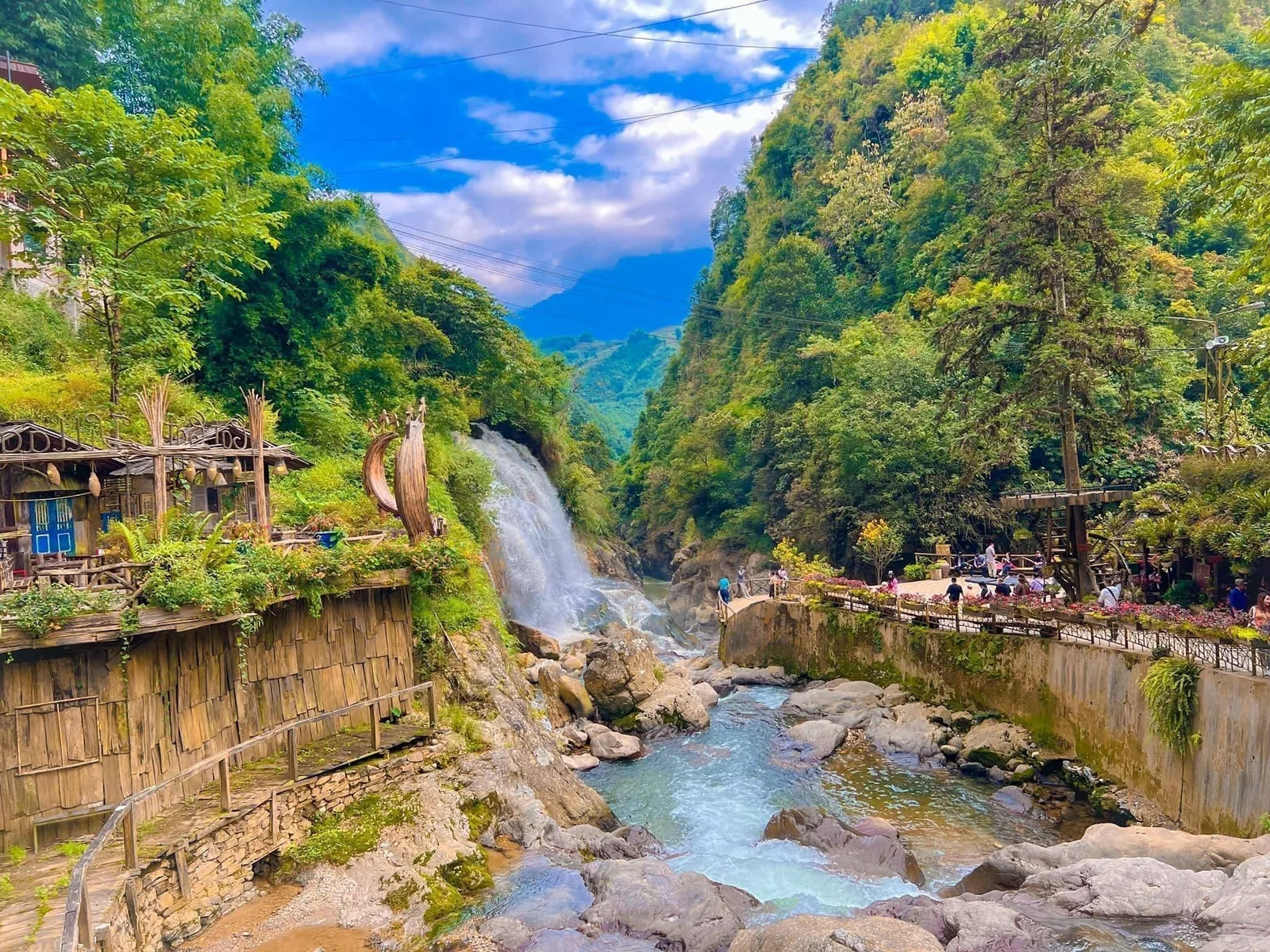A waterfall cascades through rocky terrain surrounded by lush green hills at Cat Cat Village, Lao Cai. A waterfall cascades through rocky terrain surrounded by lush green hills at Cat Cat Village, Lao Cai.